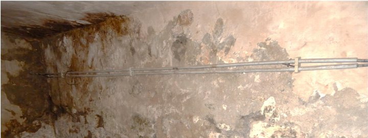 Feuchte Kellerwand mit Rostflecken und elektrischen Leitungen an der Wand, Wuppertal, Wiesenstr. 48/48a