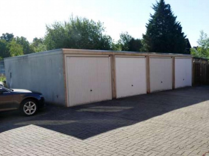 Reihe von vier Garagen mit weißen Rolltoren an der Eidinghausener Straße 198 in Bad Oeynhausen, gepflasterte Zufahrt und ein parkendes Fahrzeug