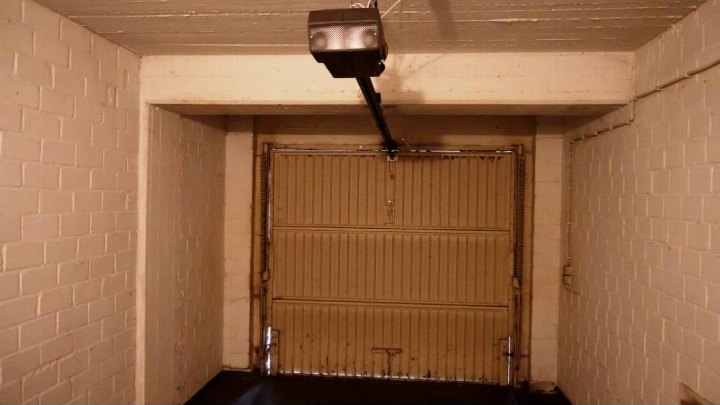 Garage mit Rolltor, Betonziegelwänden und Deckenmontage für Torantrieb