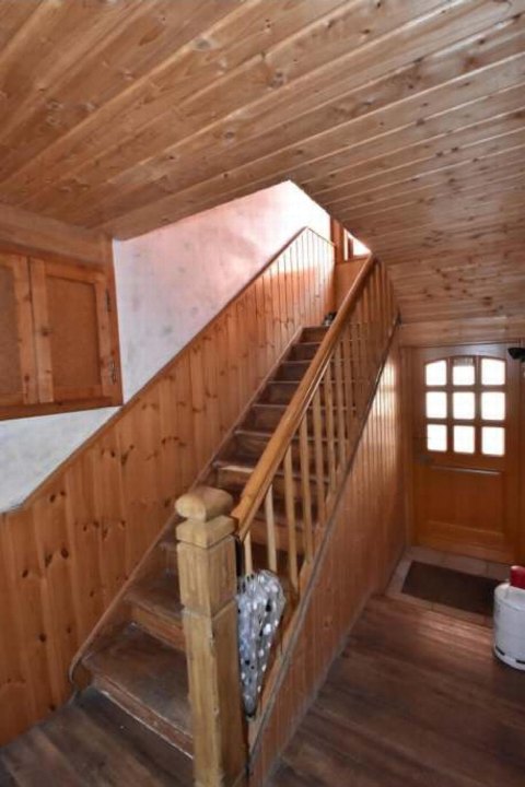 Holztreppe mit Geländer im Innenraum eines Hauses, Holzverkleidung an Wänden und Decke