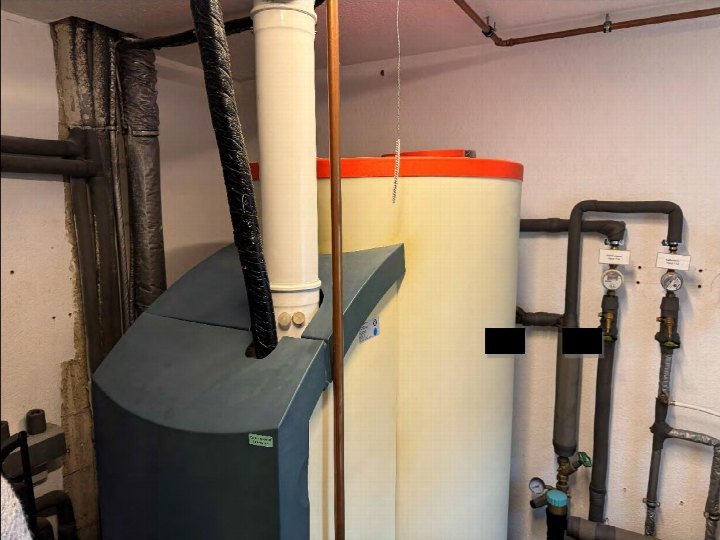 Kellerbereich mit Warmwasserboiler, Rohrleitungen und Isolierungen in einem Einfamilienhaus in Gütersloh