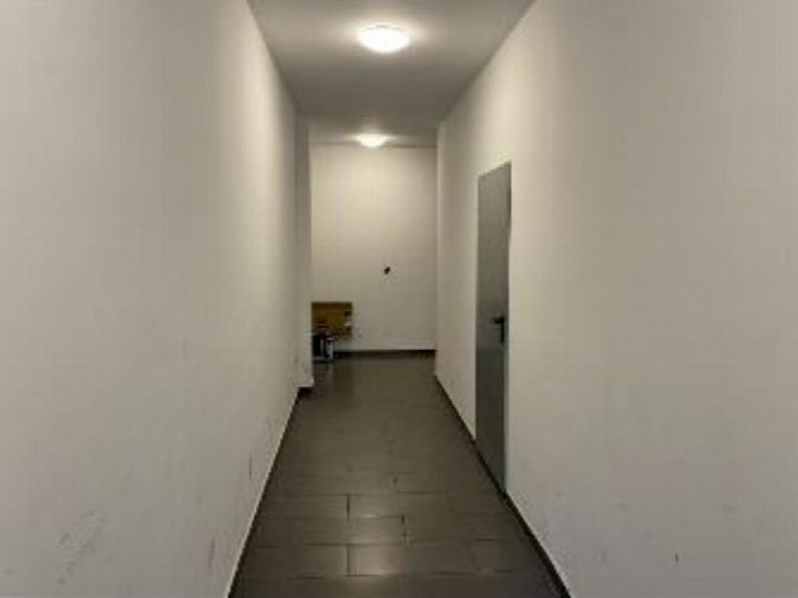 Lichter Flur mit weißen Wänden und Fliesenboden, Tür rechts, Karton am Ende, Teil eines Keller- oder Hobbyraums in Köln, Odenwaldstraße 49