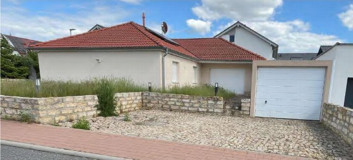 Einfamilienhaus mit rotem Ziegeldach, weißer Fassade und Garagenanbau, vorne mit Kiesweg und Steinmauer, Ranstadt, Im Kornfeld 11
