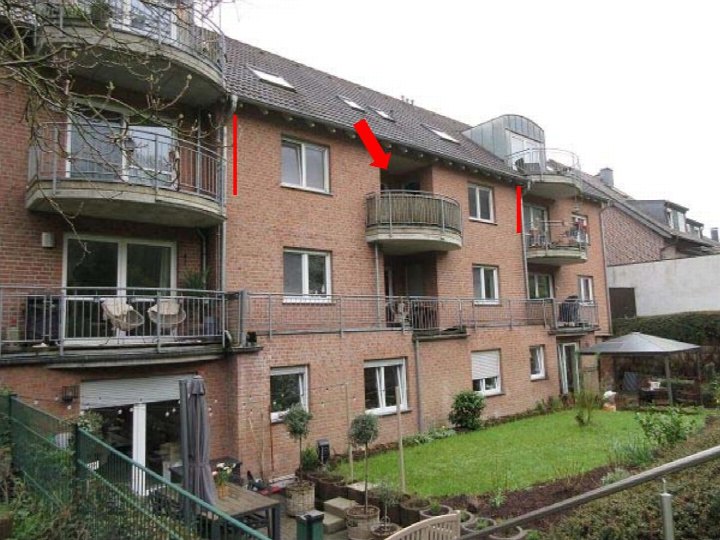 Rückansicht eines mehrstöckigen Backsteinwohnhauses mit Balkonen, Fenstern und einem Gartenbereich in Stolberg, Werkstraße 48