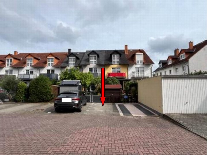 Einfahrt mit Tor und gepflastertem Weg zum Einfamilienhaus Im Themes 15 in Hausen, umgeben von Nachbarhäusern und Grünanlagen