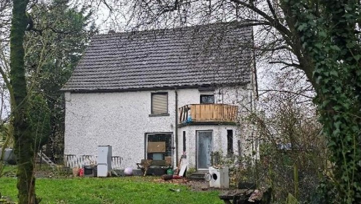 Einfamilienhaus in Sundern, Zum Rohnscheid 5, mit weiß verputzter Fassade, Satteldach und Vorgarten. Kleiner Balkon und Eingangstür sichtbar