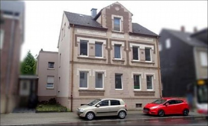 Vorderansicht eines Mehrfamilienhauses in Marl, Gudrunstraße 1a, mit geparkten Autos vor dem Gebäude