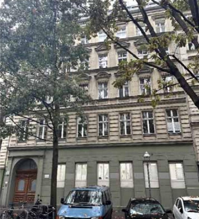 Fassade eines mehrstöckigen Wohnhauses in Berlin, Falckensteinstraße 17, mit Eingang, Fenstern und Bäumen im Vordergrund