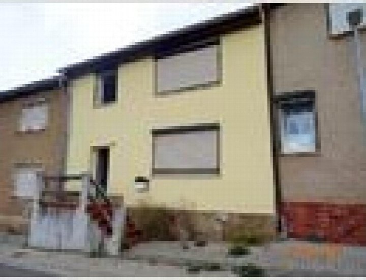 Außenansicht vorne eines Einfamilienhauses in Hettstedt, Sandberg 36, mit gelber Fassade und Fenstern