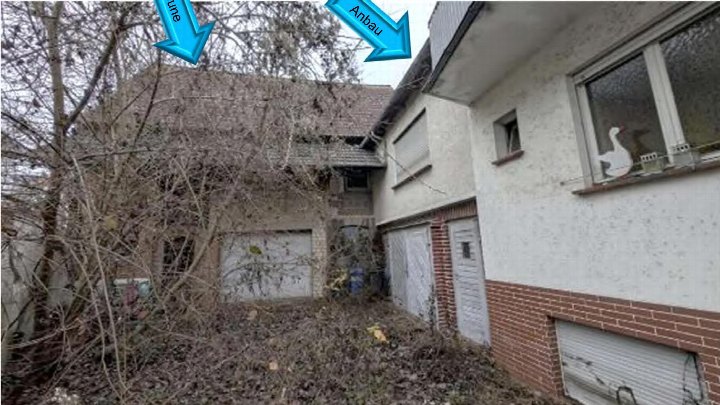 Rückansicht eines Wohnhauses mit Garage, Ziegel- und Putzfassade sowie überwuchertem Grundstück in Wetzlar, Heinestraße 6