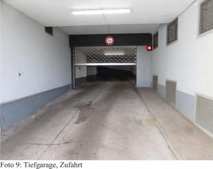 Zufahrt zur Tiefgarage mit Betonboden, Rolltor und Höhenbegrenzungsschild (1,1 m)
