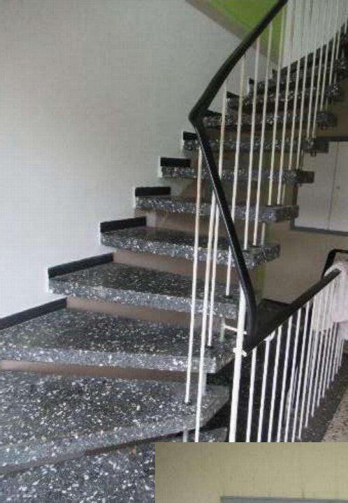 Innenansicht einer Treppe mit grau-schwarzen Stufen und weißem Metallgeländer in einem Gebäude in Datteln, Parkweg 20