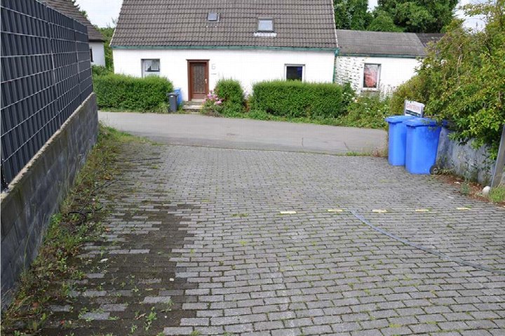Pflastersteine gepflasterte Einfahrt mit Mülltonnen vor einem Einfamilienhaus in Wermelskirchen