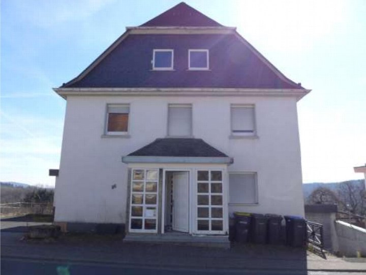 Vorderansicht eines zweistöckigen Gebäudes mit Satteldach, Eingang mit Glastüren und Fenstern, Standort Westerwaldstraße 16, Herborn