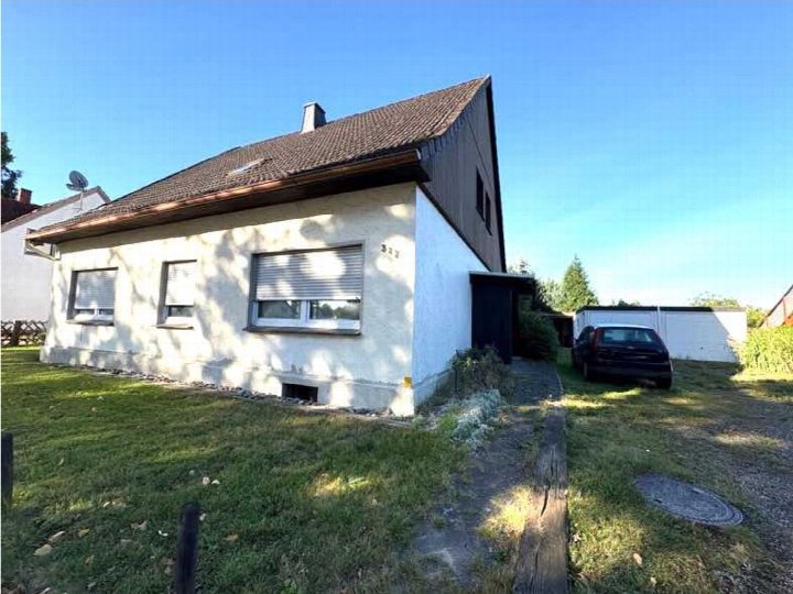 Einfamilienhaus an der Lübbecker Str. 317 in Löhne, Seitenansicht mit Garten und Dachansicht unter klarem Himmel