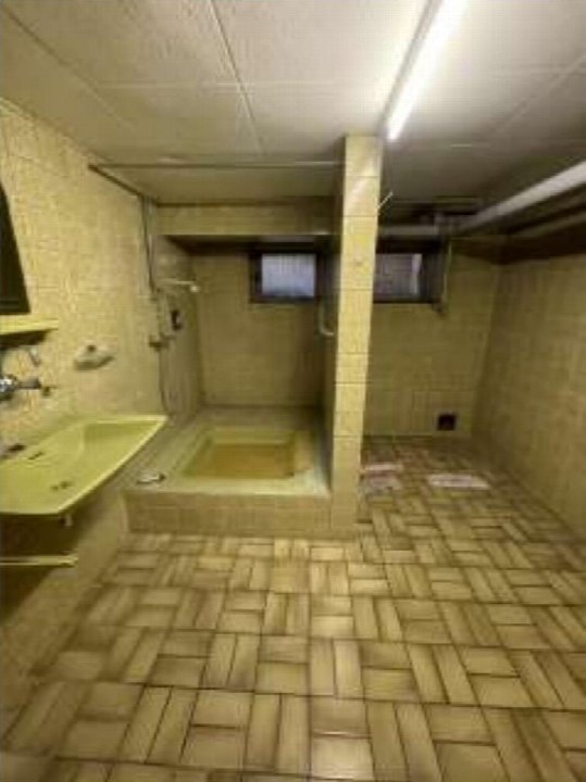 Badezimmer mit Fliesenboden, Waschbecken und Dusche, Teil einer Doppelhaushälfte in Duisburg