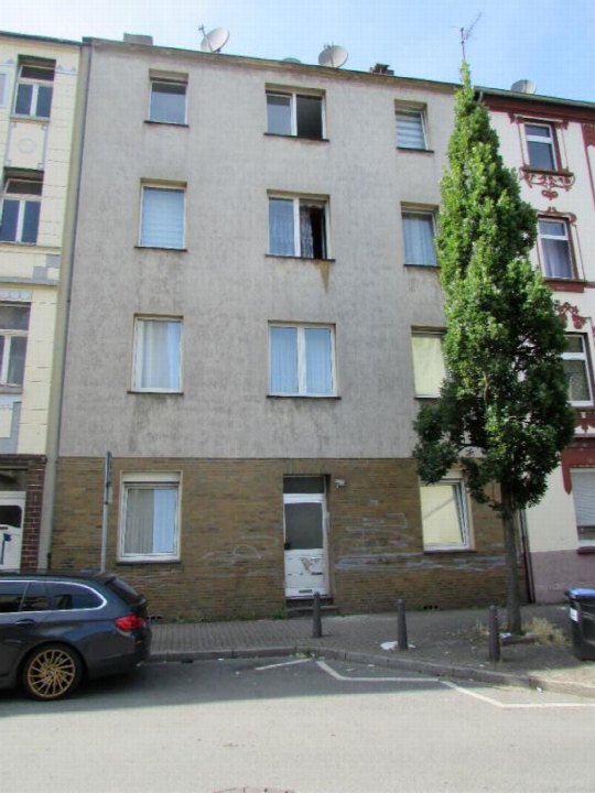 Fassade eines mehrstöckigen Wohnhauses in Duisburg, Antonienstraße 24, mit Eingangstür, Fenstern und geparktem Auto vorne