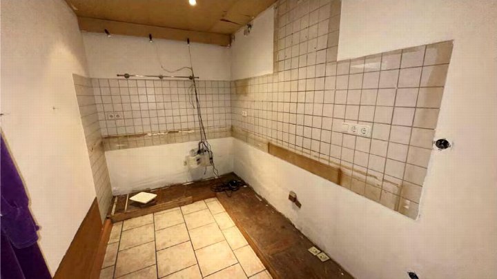 Innenraum einer Garage mit Fliesenwänden, Holzboden und sichtbaren Kabeln, Hopfenstraße 8, Duisburg