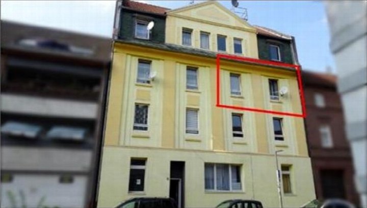 Gelbe Fassade eines Mehrfamilienhauses mit Fenstern und Dachgauben, Friesenstraße 5, Marl