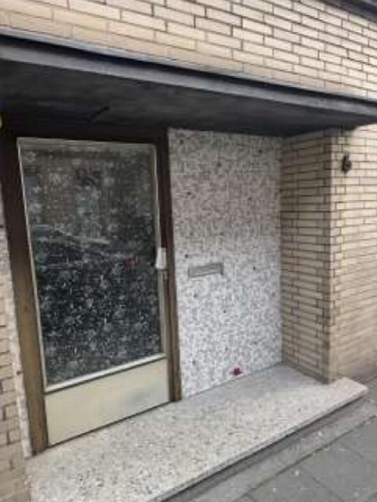 Eingangsbereich einer Eigentumswohnung mit Glastür, Fliesenwand und Betonstufe in Duisburg-Marxloh