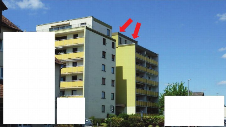 Außenansicht eines mehrstöckigen Wohngebäudes mit gelben Balkonen und hellgrauer Fassade unter blauem Himmel