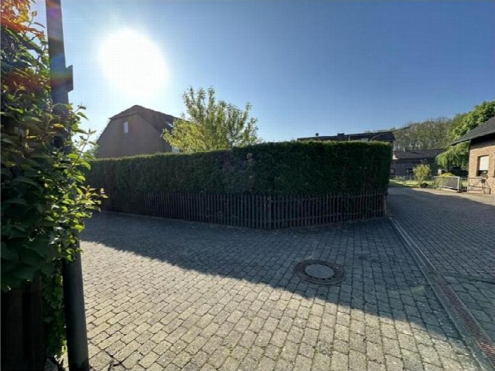 Pflasterweg mit Hecke und Holzzaun, im Hintergrund Gebäude und Bäume, Gartenbereich einer Doppelhaushälfte in Köln