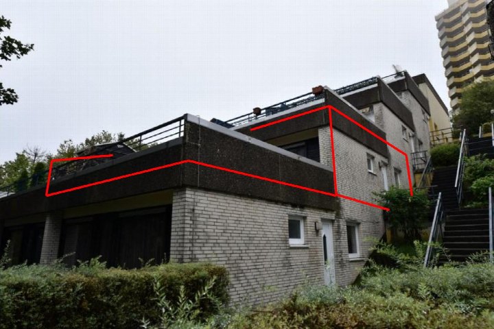 Seitenansicht eines mehrstöckigen Gebäudes mit Ziegelmauerwerk, Fenstern und Dachterrasse mit Geländer in Braunlage