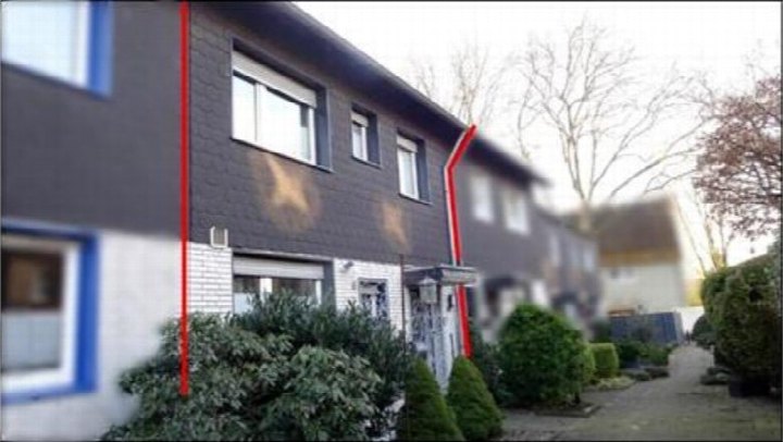 Seitenansicht eines Einfamilienhauses mit dunkler Fassade, Fenstern und Gartengrün in Marl, Gudrunstraße 1a