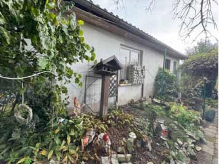 Gartenbereich mit Pflanzen, Steinen und Dekorationen vor einem Teil des Einfamilienhauses in Dieburg