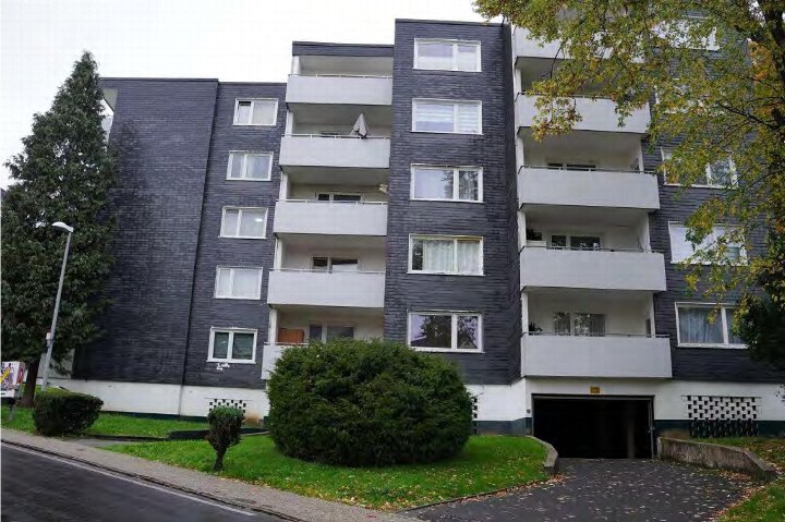 Fassade eines Mehrfamilienhauses mit Balkonen, Fenstern und Grünanlagen vorne, Hamberger Straße 57–73, Leverkusen