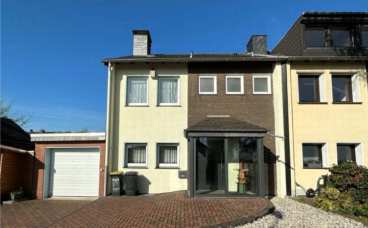 Vorderansicht eines zweistöckigen Einfamilienhauses mit Eingang, Garagenstellplatz und gepflastertem Vorplatz in Duisburg, Schulstr. 107 a