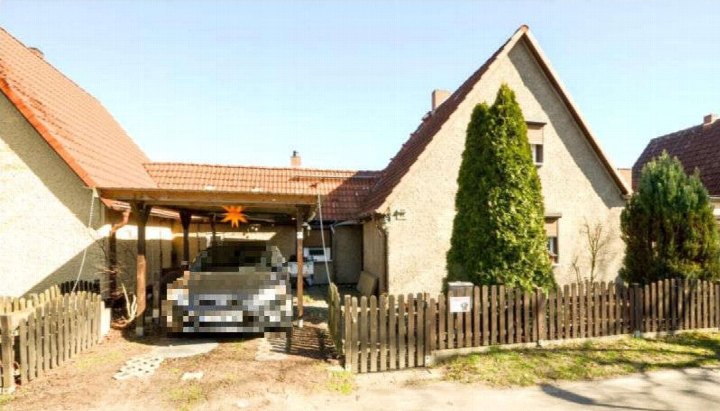 Vorderansicht eines Reihenhauses mit Ziegeldach, Holzcarport und Zaun im Vorgarten, Am Backofenberg 44, Leegebruch