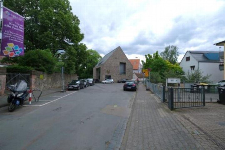 Außenansicht eines Steinhauses mit Satteldach an der Graebe Straße 12 in Frankfurt am Main, umgeben von Bäumen und geparkten Fahrzeugen