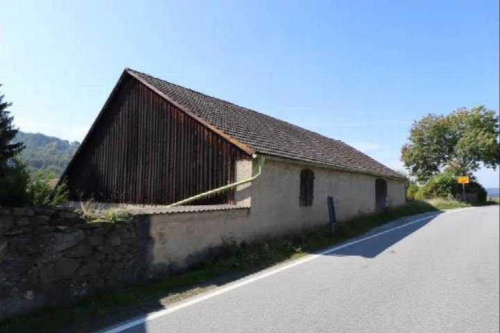 Seitenansicht eines Gebäudes mit Satteldach und verputzter Wand an einer Straße in Doberschau-Gaußig