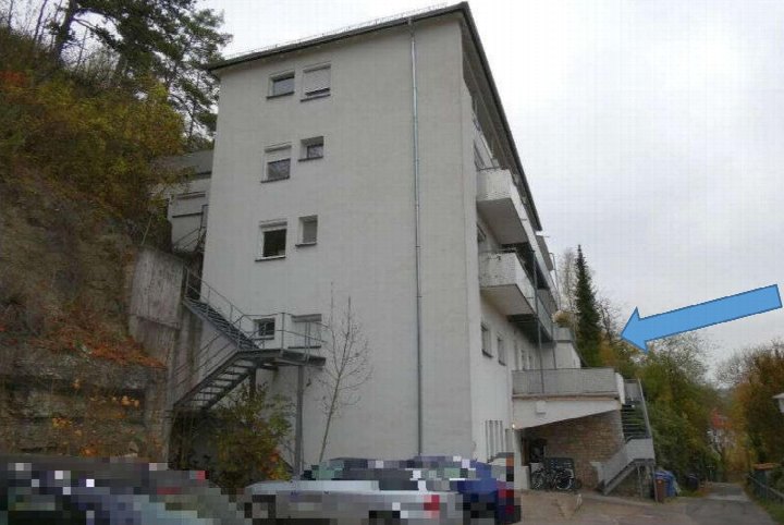 Seitenansicht eines mehrstöckigen Wohngebäudes mit Balkonen, Außentreppe und angrenzender Bepflanzung in Bad Mergentheim, Ketterburgweg 6