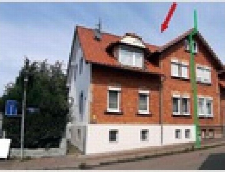 Vorderansicht eines Doppelhaushalftes mit rotem Ziegeldach, Backsteinfassade und weißen Fensterrahmen in Aalen, Georg-Röhm-Straße 4b