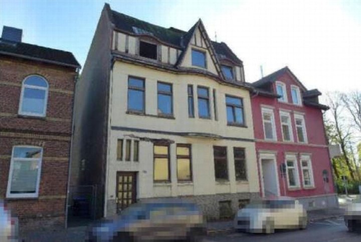 Fassade eines mehrstöckigen Gebäudes in Itzehoe, Kaiserstraße 2, mit Fenstern, Dachgauben und angrenzenden Häusern