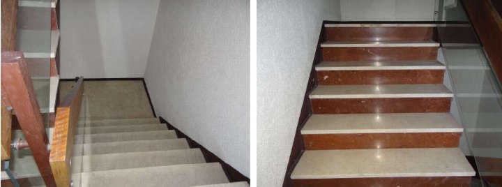 Innenansicht einer Treppe mit Marmorstufen, Holzgeländern und Glasbrüstungen in einer Eigentumswohnung