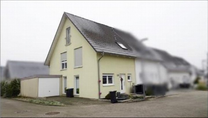 Vorderansicht eines gelben Zweifamilienhauses mit Satteldach, Eingangstür, Fenstern und Nebengebäude, Quellenweg 22, Gelsenkirchen