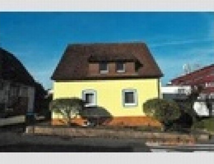 Gelbes Zweifamilienhaus mit braunem Satteldach und Dachgauben, Vorderansicht mit Garten und Hecken, Gaildorf, Kochstraße 10