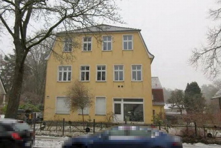 Gelbes Mehrfamilienhaus mit Eingang und Fenstern, vorne gesehen, im Winter mit leichtem Schnee, Hohen Neuendorf, Clara-Zetkin-Straße 27