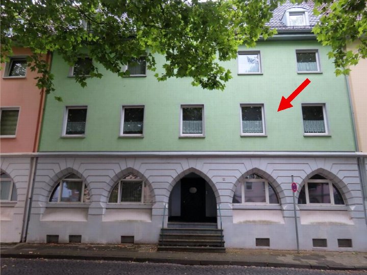 Fassade eines mehrstöckigen Wohnhauses in Aachen, Sedanstraße 26, mit grünem Obergeschoss, grauem Sockelgeschoss und Eingangstreppe
