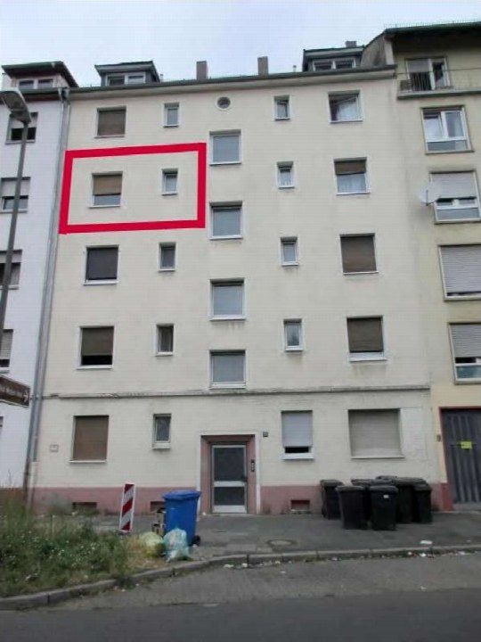 Außenansicht der Fassade eines Mehrfamilienhauses mit Eingang, Fenstern und Mülltonnen im Vordergrund in Ludwigshafen am Rhein