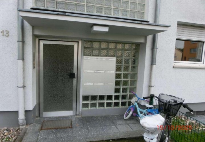 Eingangsbereich der Eigentumswohnung Stralsunder Straße 13 in Troisdorf mit Tür, Briefkästen und Glasbausteinen