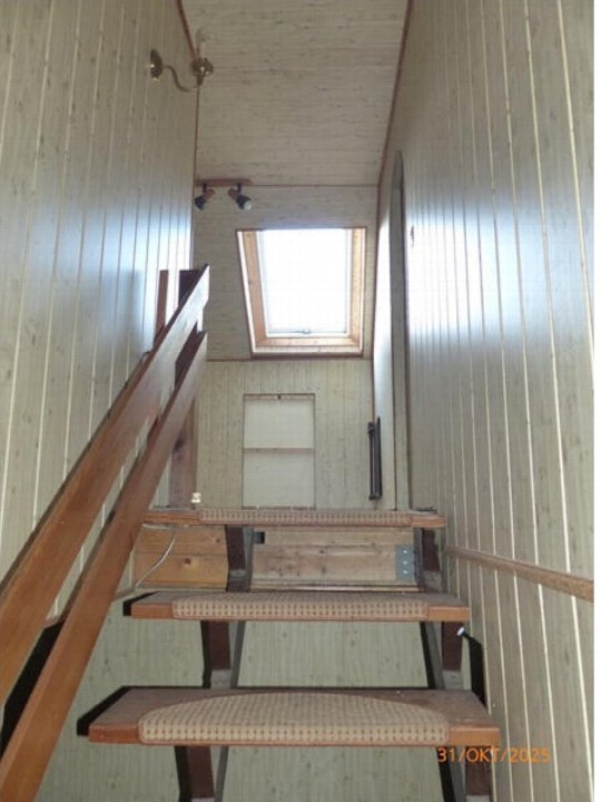 Innenansicht einer Holztreppe mit Gitterstufen und Dachfenster im Obergeschoss eines Einfamilienhauses in Bennewitz