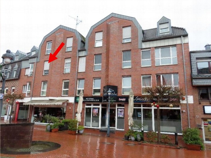 Vorderansicht eines mehrstöckigen Backsteinhauses mit Geschäften im Erdgeschoss und Wohnungen darüber, Hauptstraße 14, Wegberg