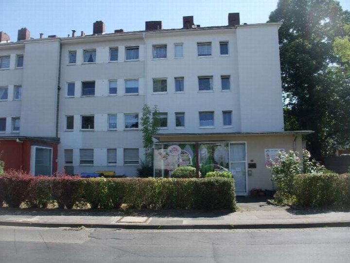 Vorderansicht eines mehrstöckigen Wohn- und Geschäftshauses mit Eingang, Fenstern und Hecke im Vorgarten in Bonn, Schieffelingsweg 18