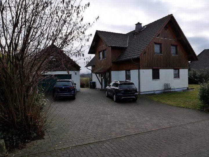 Einfamilienhaus mit Holzfassade und Ziegeldach, Vorderansicht mit Einfahrt und geparkten Fahrzeugen, Dorfwiesenweg 3, Eichenzell