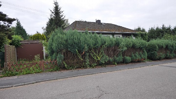 Seitenansicht eines Einfamilienhauses mit Dach, Hecke und Zaun an der Keltenstraße 31 in Kall