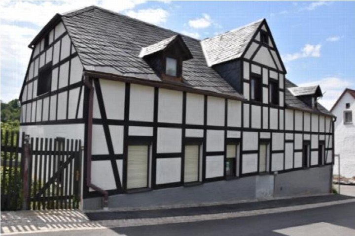 Seitenansicht eines Fachwerkhauses mit grauem Satteldach, Fenstern und Dachgauben in Reichenbach, Alaunstraße 6